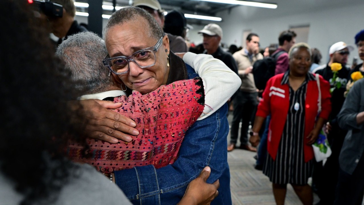 Two individuals comforting each other during the one-year anniversary of the Eaton Fire.